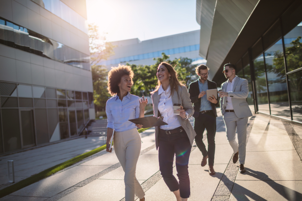 Group of office workers walking in front of building.