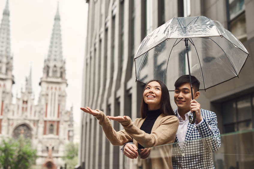 Man protecting a woman from rain underneath an umbrella