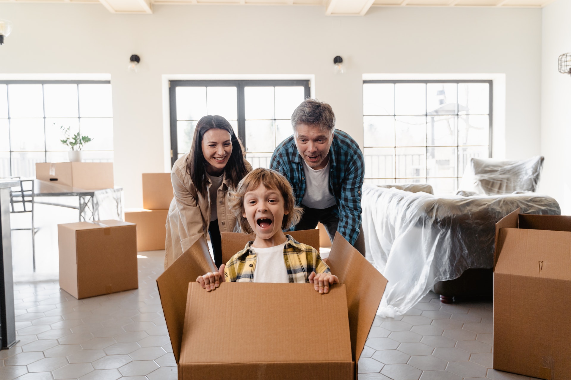 Parent with child sitting in moving box.