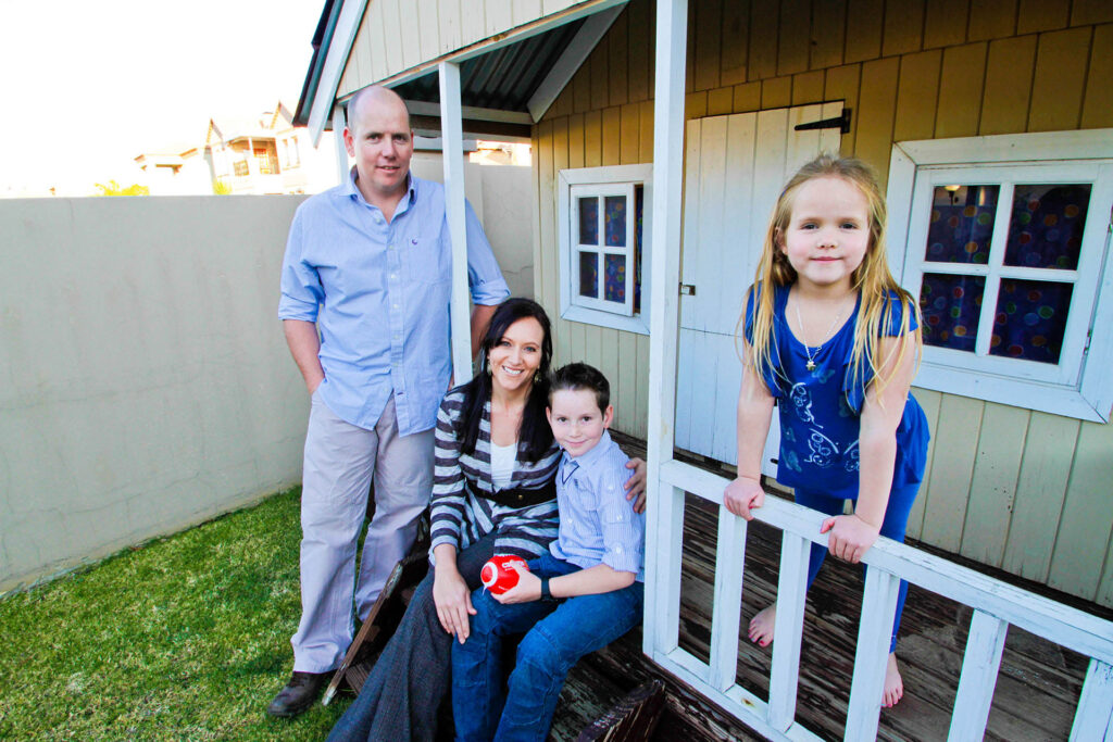 Family outside a cubby house